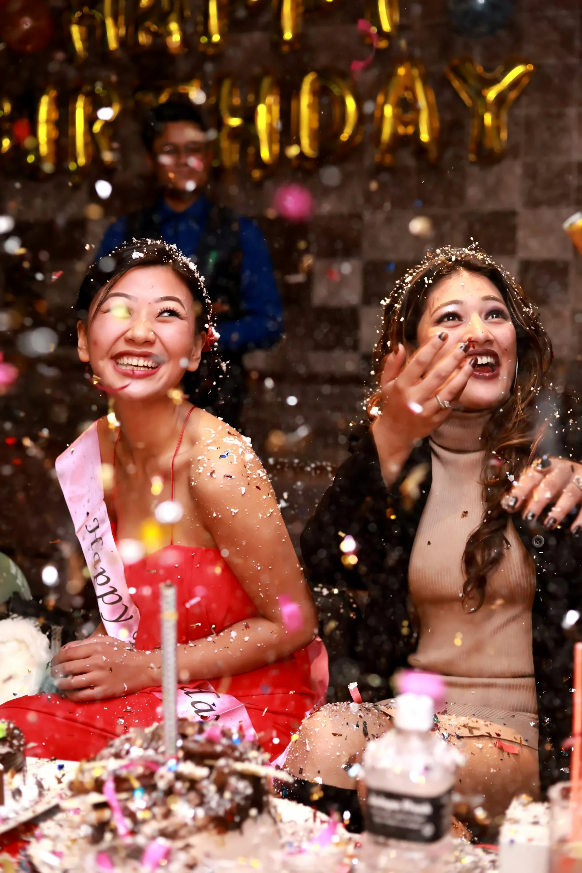 Deux amies lançant des paillettes pendant une fête